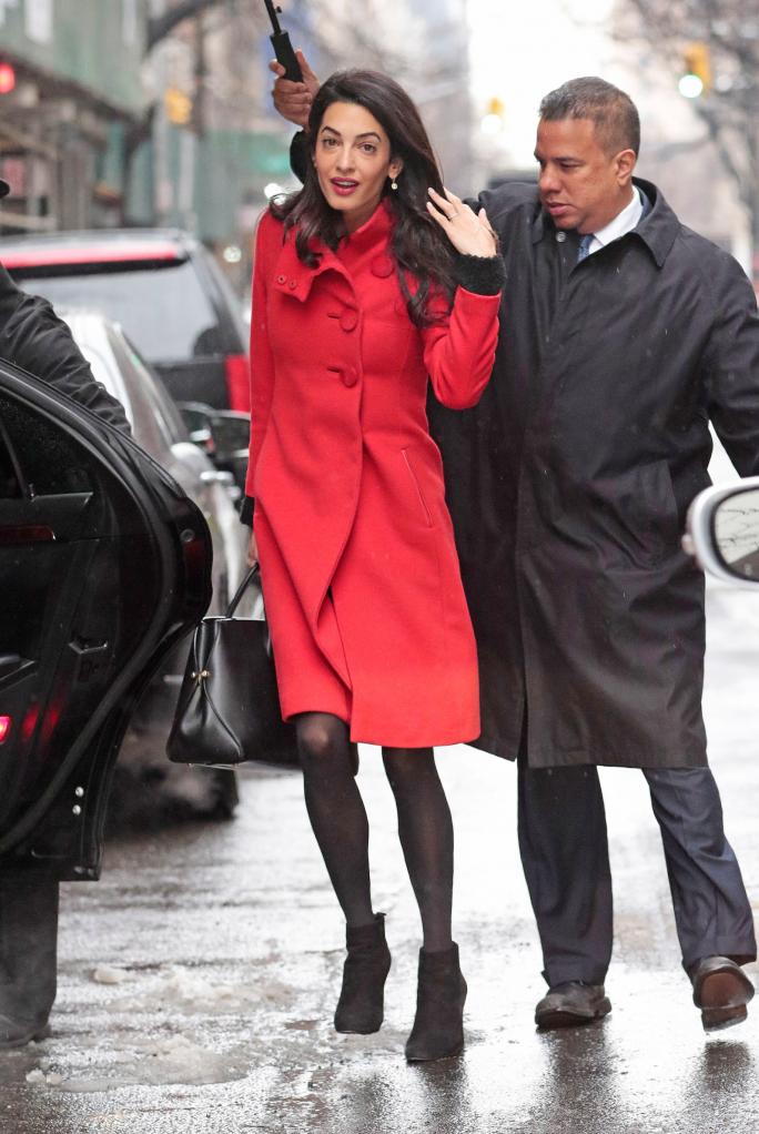 EXCLUSIVE: Amal Alamuddin Clooney wears a red coat while navigating the snow storm in New York City