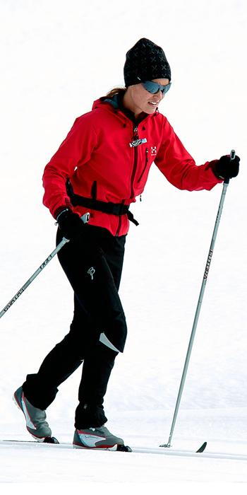 पिप्पा Middleton - red ski jacket, black snow pants, a black hat, and sporty shades